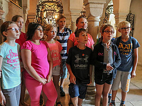 Das Foto zeigt eine Schülergruppe bei der Besichtigung des Gurker Doms. Ehrfürchtig lauschen sie den Ausführungen unserer Guides. 